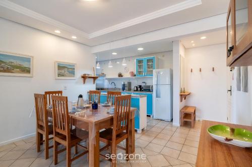 a kitchen with a table and chairs and a refrigerator at Apto com Vista Mar a 214m da Praia - BLU0206 in Florianópolis