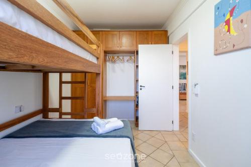 a bedroom with a bunk bed and a closet at Apto com Vista Mar a 214m da Praia - BLU0206 in Florianópolis