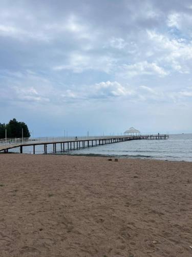 a pier in the water with a sandy beach at Отель Асман in Bosteri