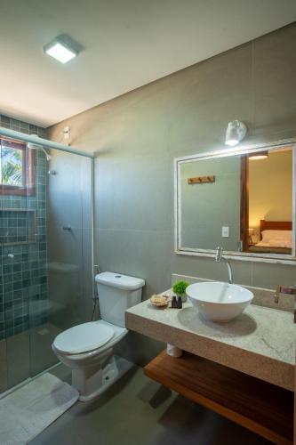 a bathroom with a toilet and a sink and a shower at Paraiso da Barra in Barra Grande