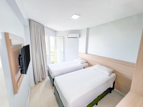 a hospital room with two beds and a tv at diRoma Império direto com o Grupo diRoma com acesso ao Acqua Park e Café da manhã in Caldas Novas