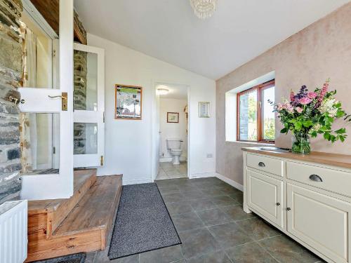 a bathroom with a vase of flowers on a counter at 2 Bed in Brechfa 55903 in Rhyd-cymmerau