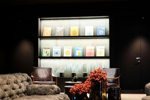 a room with two chairs and a window with books at 4K in Wangen im Allgäu