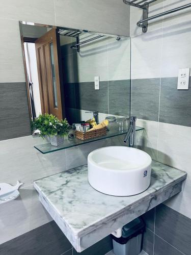 a bathroom with a sink and a mirror at The Sun Hotel in Long Bình