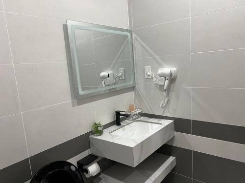 a bathroom with a white sink and a mirror at The Sun Hotel in Long Bình
