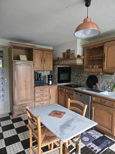 a kitchen with wooden cabinets and a table with chairs at Ty Flour Di Lys in Rochefort-en-Terre