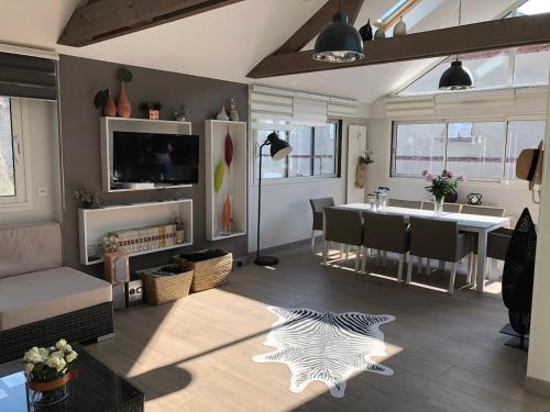 a living room with a table and a dining room at Villa Le Rubis in Agon Coutainville