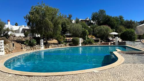 a large swimming pool with blue water in a yard at Casa Luca in Carvoeiro