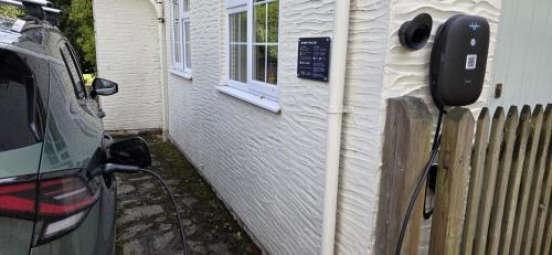 a parking meter next to a car next to a house at Wey House Withypool in Withypool