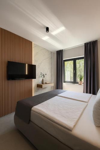 a bedroom with a large bed and a television on a wall at Villa VELUNA Liznjan Residence in Ližnjan