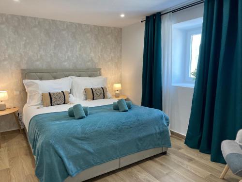 a bedroom with a large bed with a blue blanket at Peaceful Mountain Getaway - A Herança in Vila de Rei