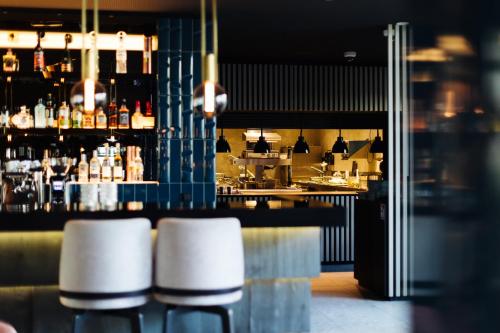 a bar with three stools in front of a counter at 4K in Wangen im Allgäu