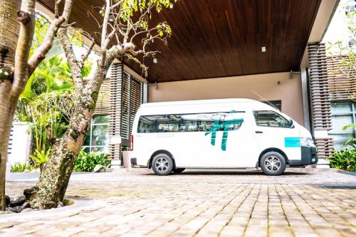 a white van parked in front of a building at Holiday Inn Mauritius Mon Trésor by IHG in Blue Bay