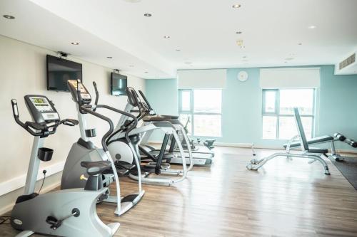 a gym with several treadmills and cardio machines at Holiday Inn Mauritius Mon Trésor by IHG in Blue Bay