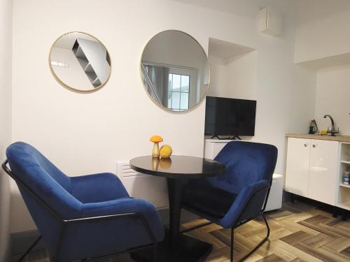 a room with two blue chairs and a table and a mirror at Loft Style-1Br-WalkinShower-WiFi-Central Cork in Cork