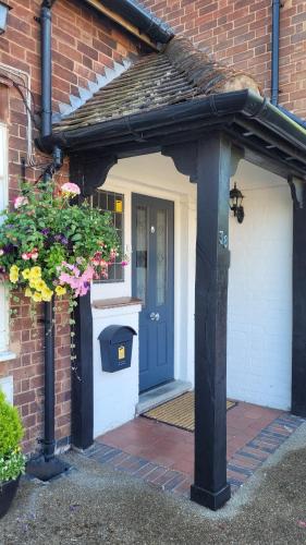 an entrance to a brick house with a blue door at Hampton Lodge En-Suite Rooms with Free Parking in Stratford-upon-Avon
