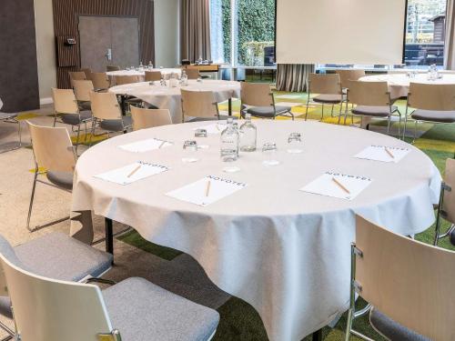 a group of tables and chairs in a room at Novotel Luxembourg Kirchberg in Luxembourg