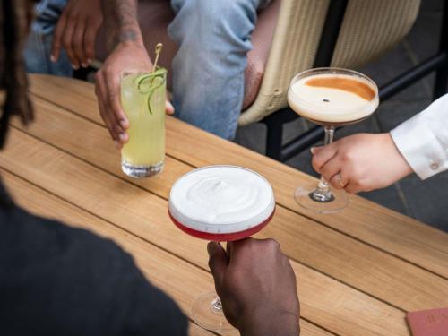 a group of people sitting at a table with drinks at Novotel Luxembourg Kirchberg in Luxembourg