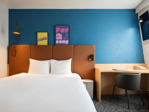 a hotel room with a bed and a desk and a bed and a bed petertodd at ibis Paris Gare de Lyon Ledru Rollin in Paris