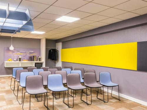 a conference room with chairs and a wall with yellow at ibis Paris Gare de Lyon Ledru Rollin in Paris