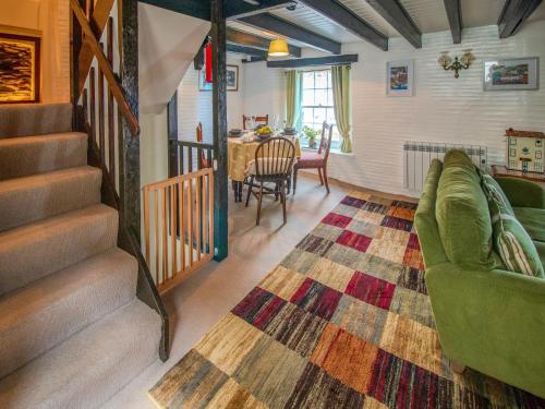 a living room with a couch and a table at Charlie Wilcox Cottage in Polperro