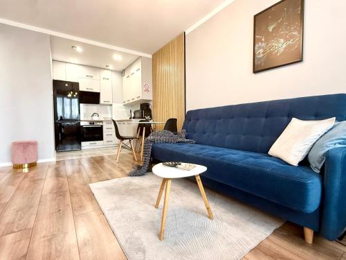 a blue couch in a living room with a table at Loft Apartament 1 in Gorzów Wielkopolski