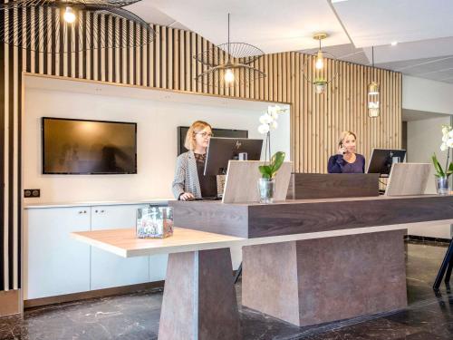 two women sitting at a desk in an office at Mercure Cavaillon in Cavaillon