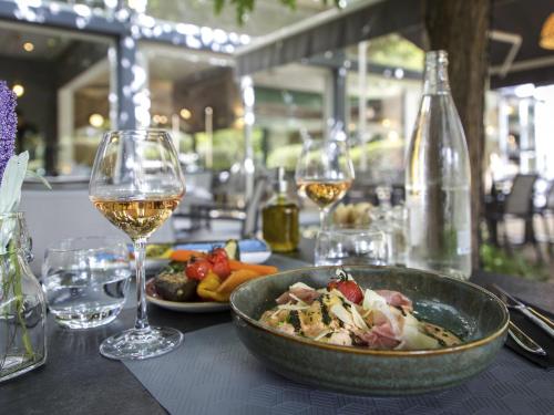 a table with a bowl of food and glasses of wine at Mercure Cavaillon in Cavaillon