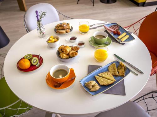 a white table with breakfast foods and drinks on it at Mercure Cavaillon in Cavaillon