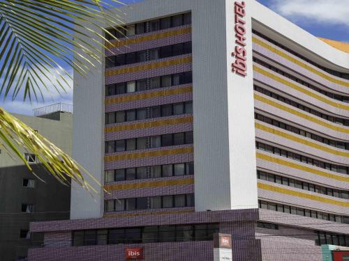 a tall building with a sign on the side of it at ibis Maceio Pajuçara in Maceió