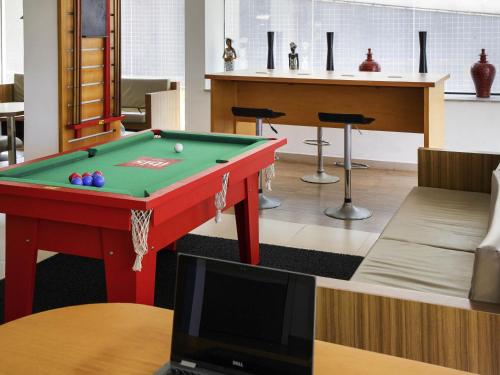 a living room with a pool table and a television at ibis Maceio Pajuçara in Maceió