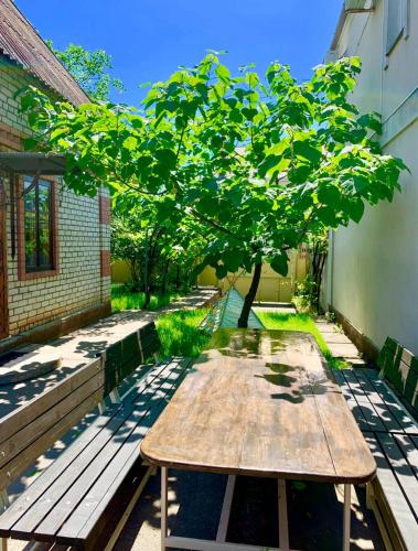 a wooden table sitting on the side of a building with a tree at Amore in Zatoka
