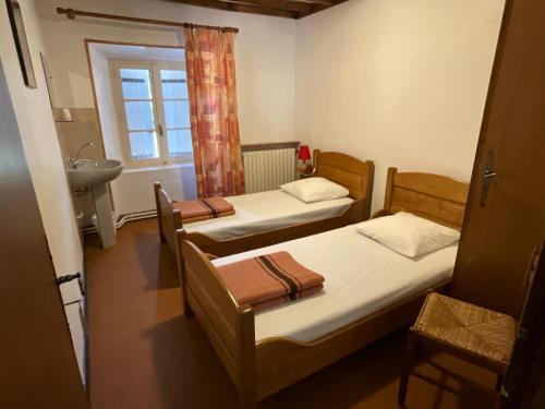 due letti in una piccola stanza con un lavandino di Maison des Cévennes - Refuge ad Arphy