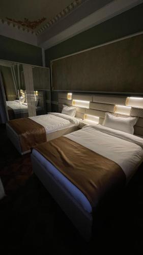 two beds in a room with lights on them at Hotel Madonna SPA in Kaskelen