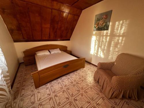 a small bedroom with a bed and a chair at Amore in Zatoka
