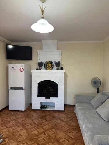 a living room with a white fireplace and a refrigerator at Amore in Zatoka
