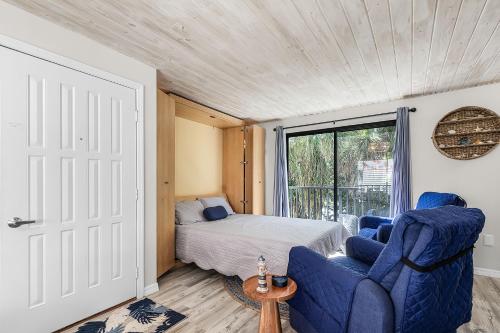 a bedroom with a bed and a blue chair at Unwind with Beach Bliss & Sunset Magic - Sunburst 113 in Punta Gorda Beach