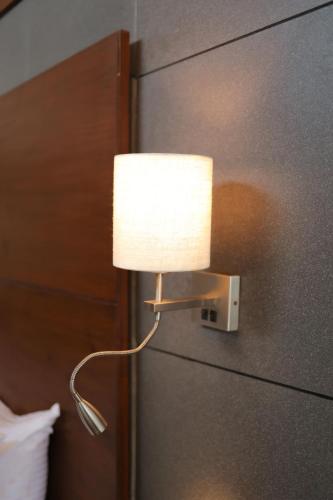 a lamp on a wall next to a refrigerator at Vee Resort- The Suites of Royals in Mahabaleshwar