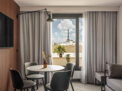 a room with a table and chairs and a window at Novotel Paris Vaugirard Montparnasse in Paris