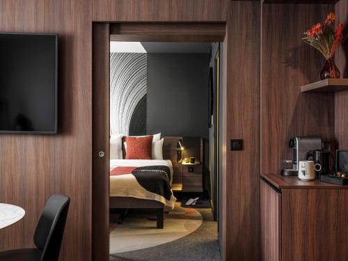 a hotel room with a bed and a television at Novotel Paris Vaugirard Montparnasse in Paris