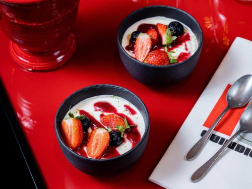 two black bowls of fruit salad on a red table at Novotel Paris Vaugirard Montparnasse in Paris