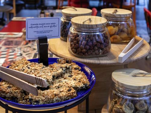 a plate of food on a table with jars of nuts at Novotel Paris Vaugirard Montparnasse in Paris