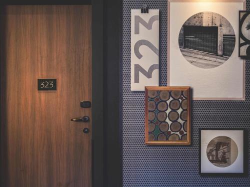 a hallway with a door and pictures on a wall at Novotel Paris Vaugirard Montparnasse in Paris