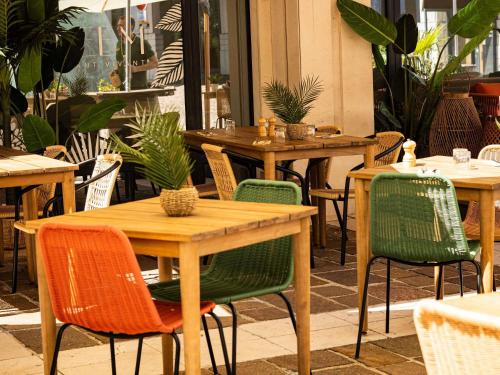 a restaurant with wooden tables and chairs and plants at Novotel Paris Pont De Sevres in Sèvres
