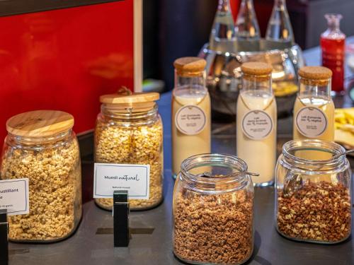 Un grupo de frascos de frutos secos sobre una mesa. en Novotel Paris Pont De Sevres, en Sèvres