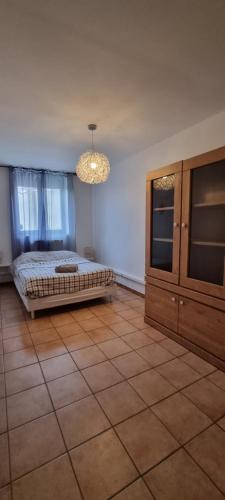 a bedroom with a bed and a cabinet and a chandelier at T4 rénové 95 m2 cosy confort ! in Anzin