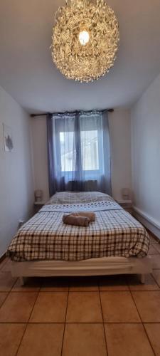 a bedroom with a bed and a chandelier at T4 rénové 95 m2 cosy confort ! in Anzin