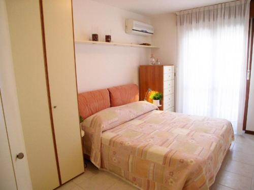 een kleine slaapkamer met een bed en een raam bij Lina's Apartment in Grado