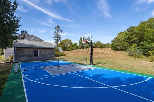 a tennis court with a basketball hoop at Stay On The Cape Vacation Rentals: Immaculate Home 2 Acres Short Walk To Beach in Bourne