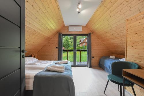 a room with two beds and a desk and a window at Domki Salamandra Lipowa in Lipowa